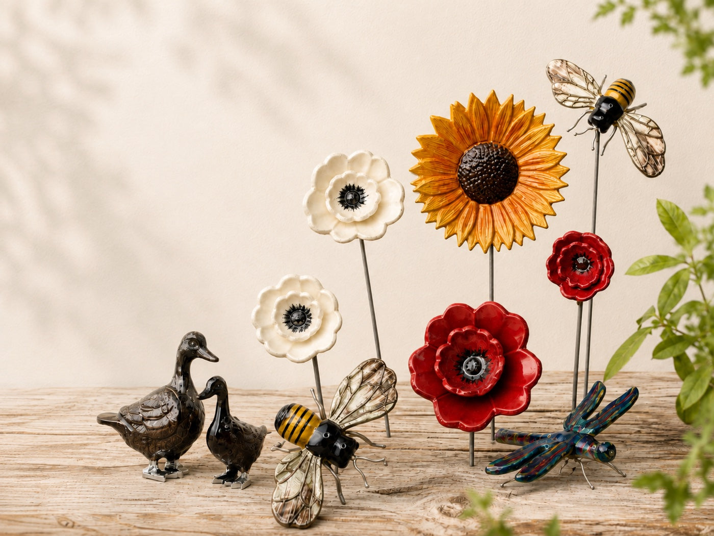 Ceramic flower garden stakes, bee and duck ornaments arranged on weathered wood